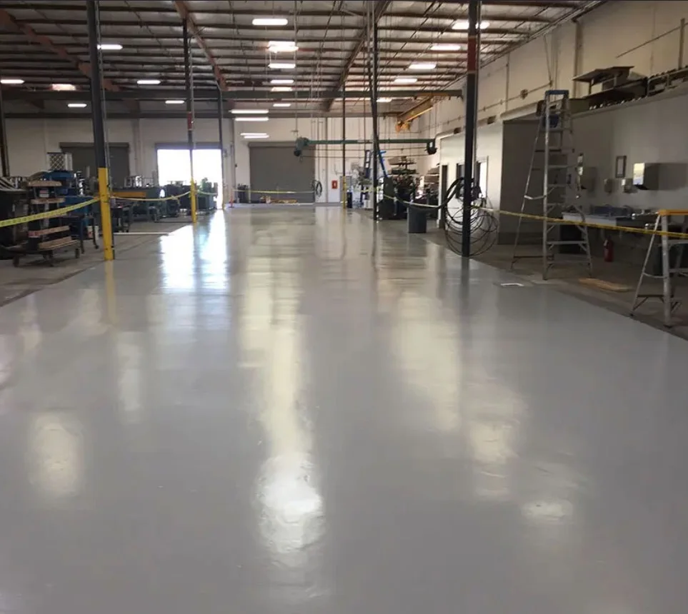 Gray epoxy floor across an industrial production facility