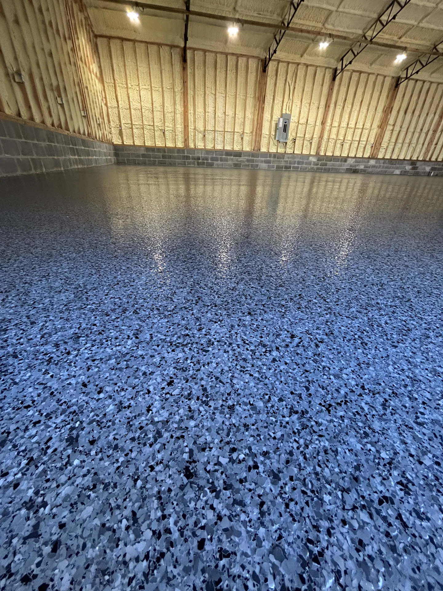 Blue decorative flake epoxy floor in a residential metal building