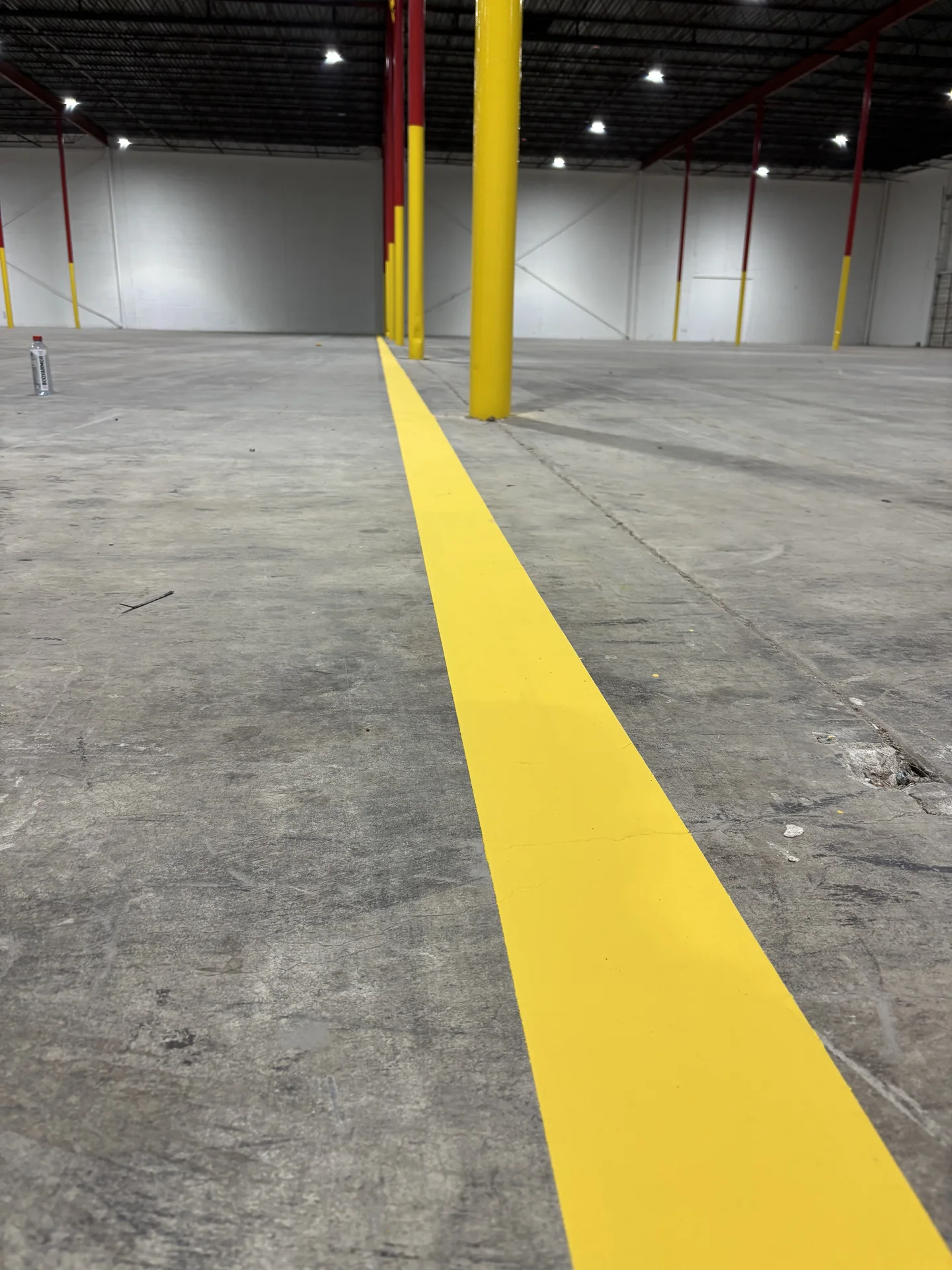 Yellow floor striping through a warehouse interior