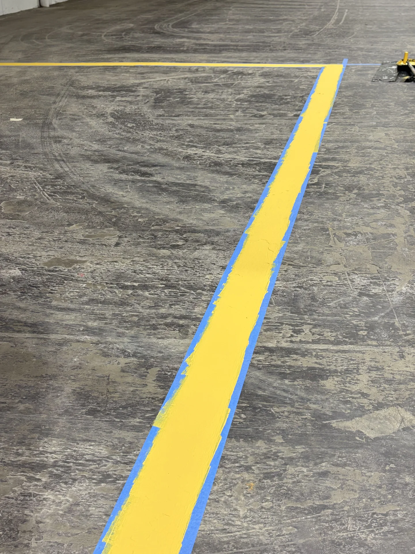 Yellow stripe with masking tape during floor marking work