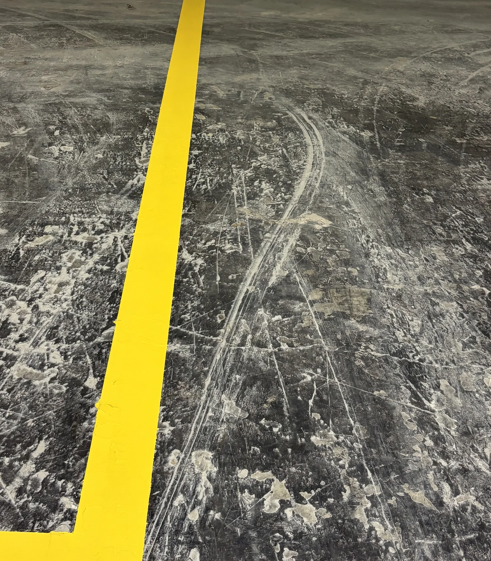 Yellow floor striping detail on an industrial concrete surface
