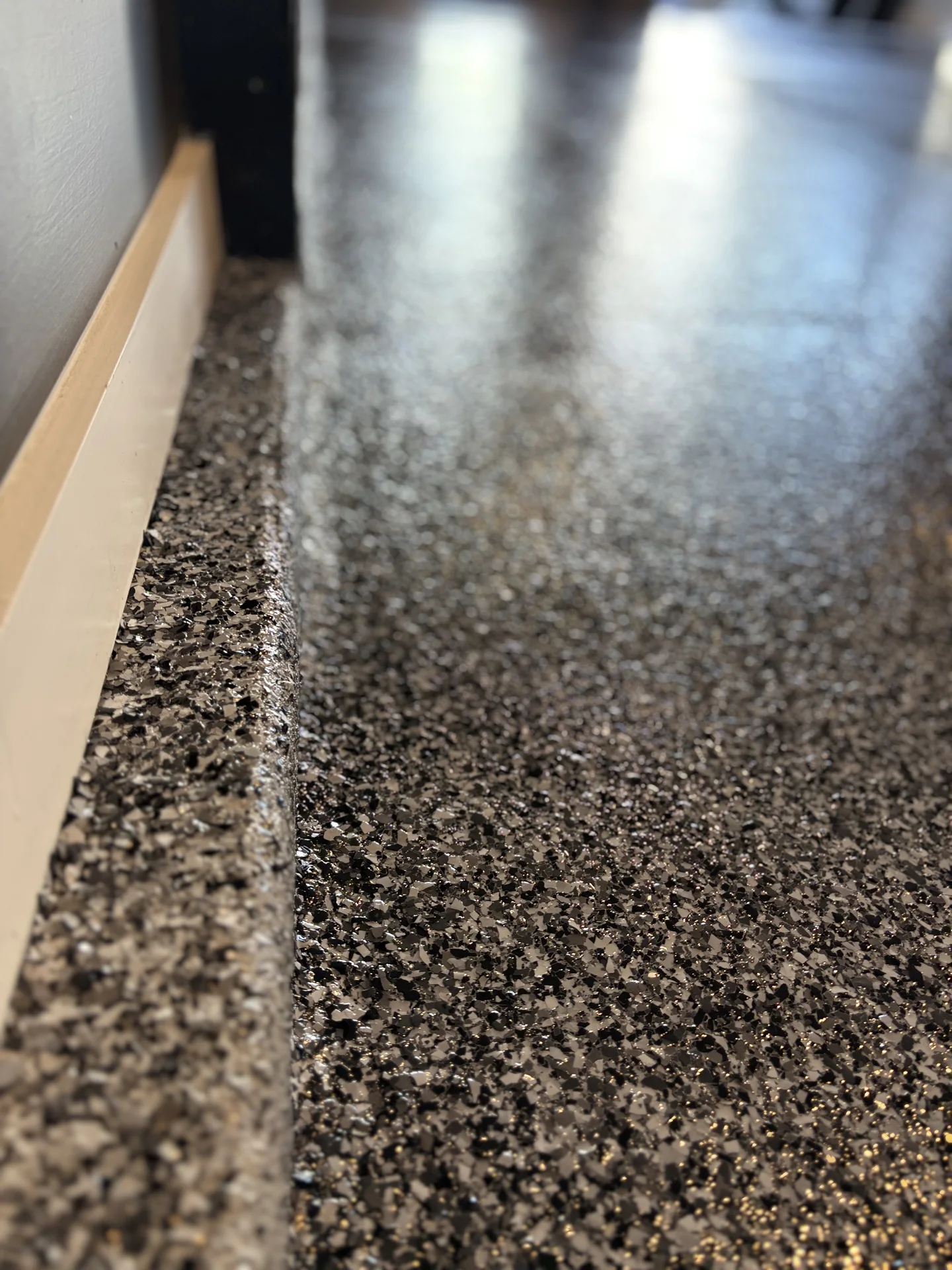 Decorative flake coating detail at a garage threshold