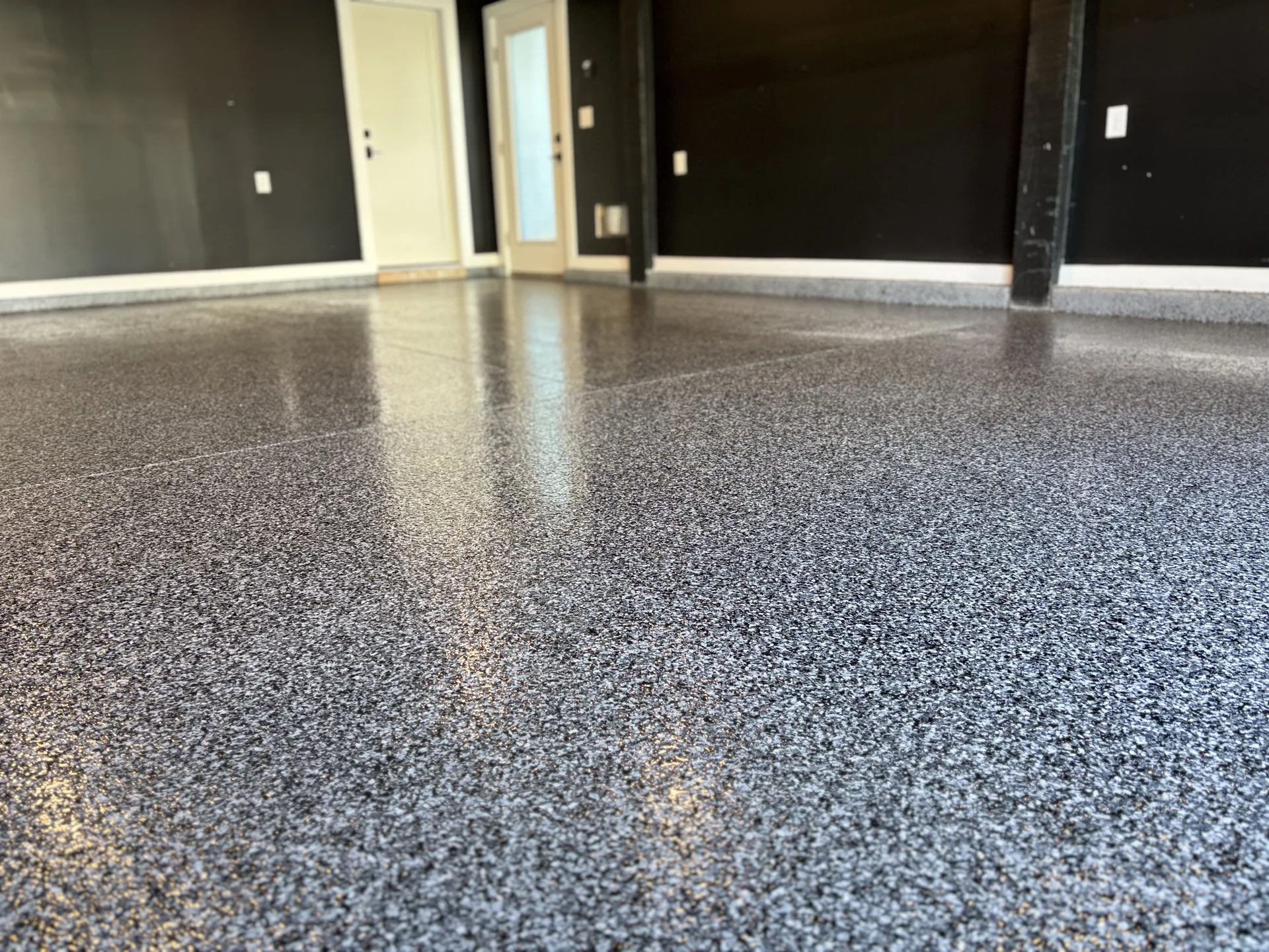 Wide residential garage with a finished gray coating